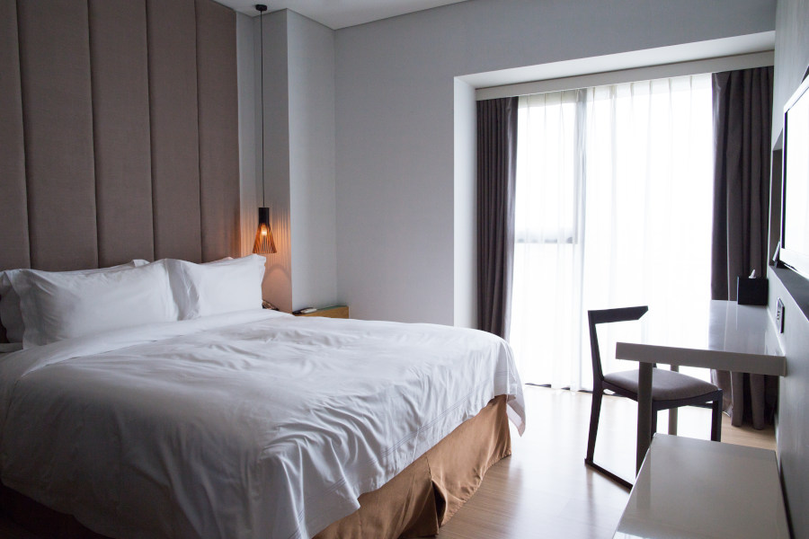 Hotel bedroom with double bed, table and TV set Hotel bedroom with double bed, table and TV set